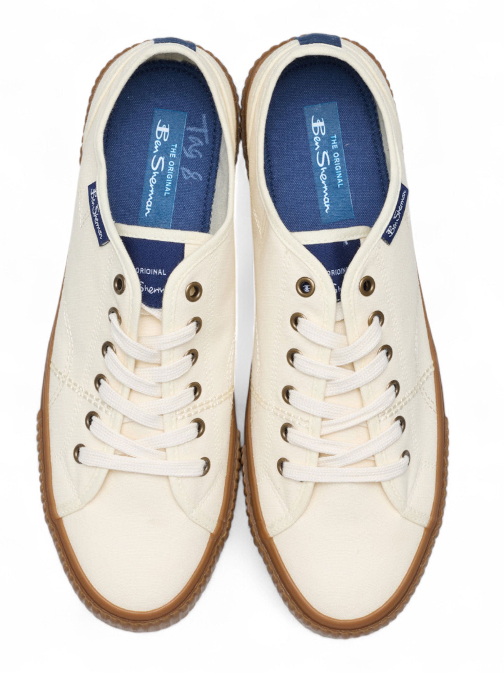 Pair of white sneakers with brown soles on a white background