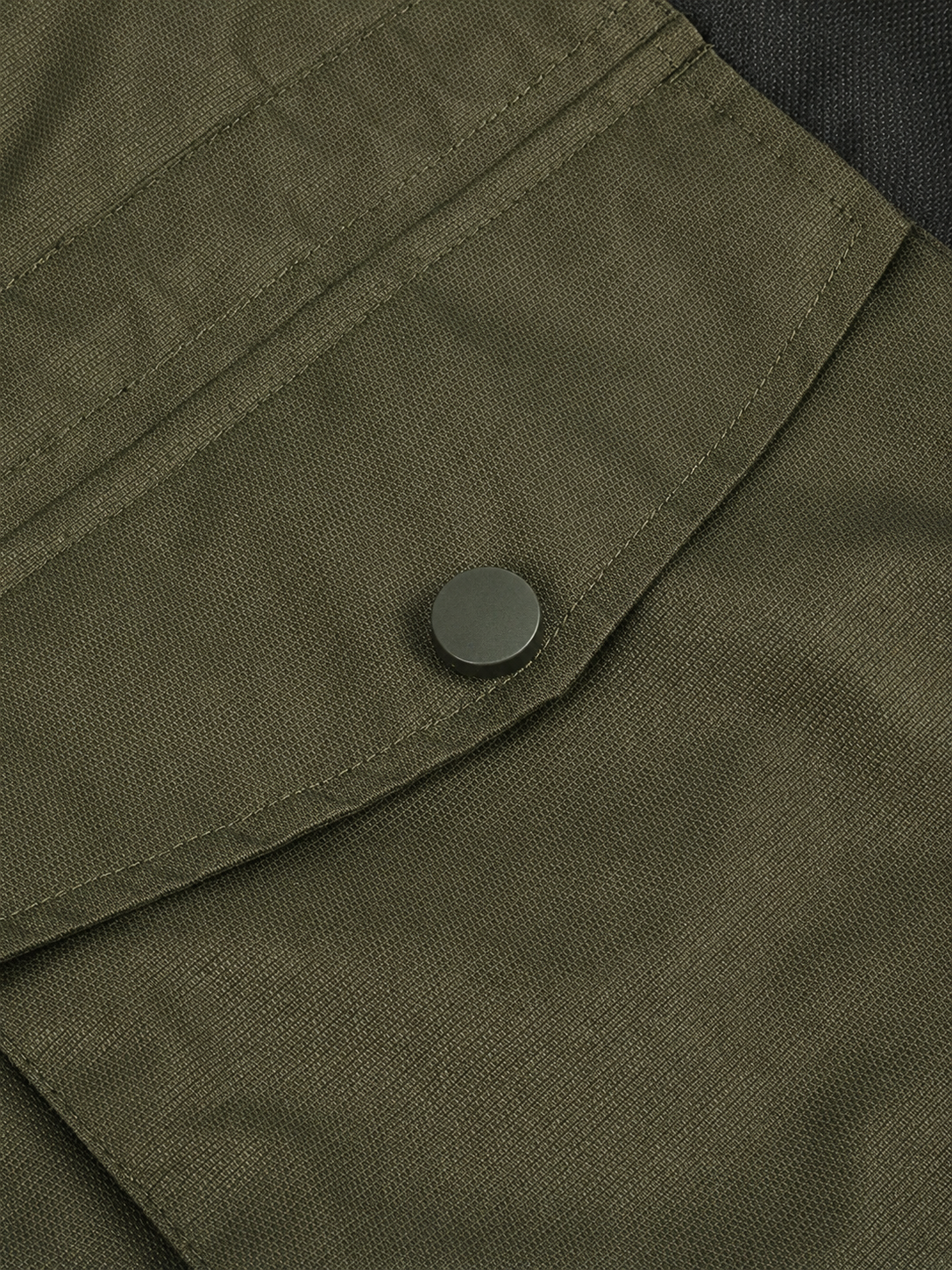 Close-up of a green fabric with a button, from a jacket.