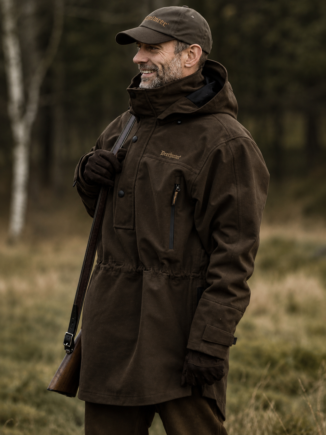 Man wearing a brown jacket and cap in a forest setting