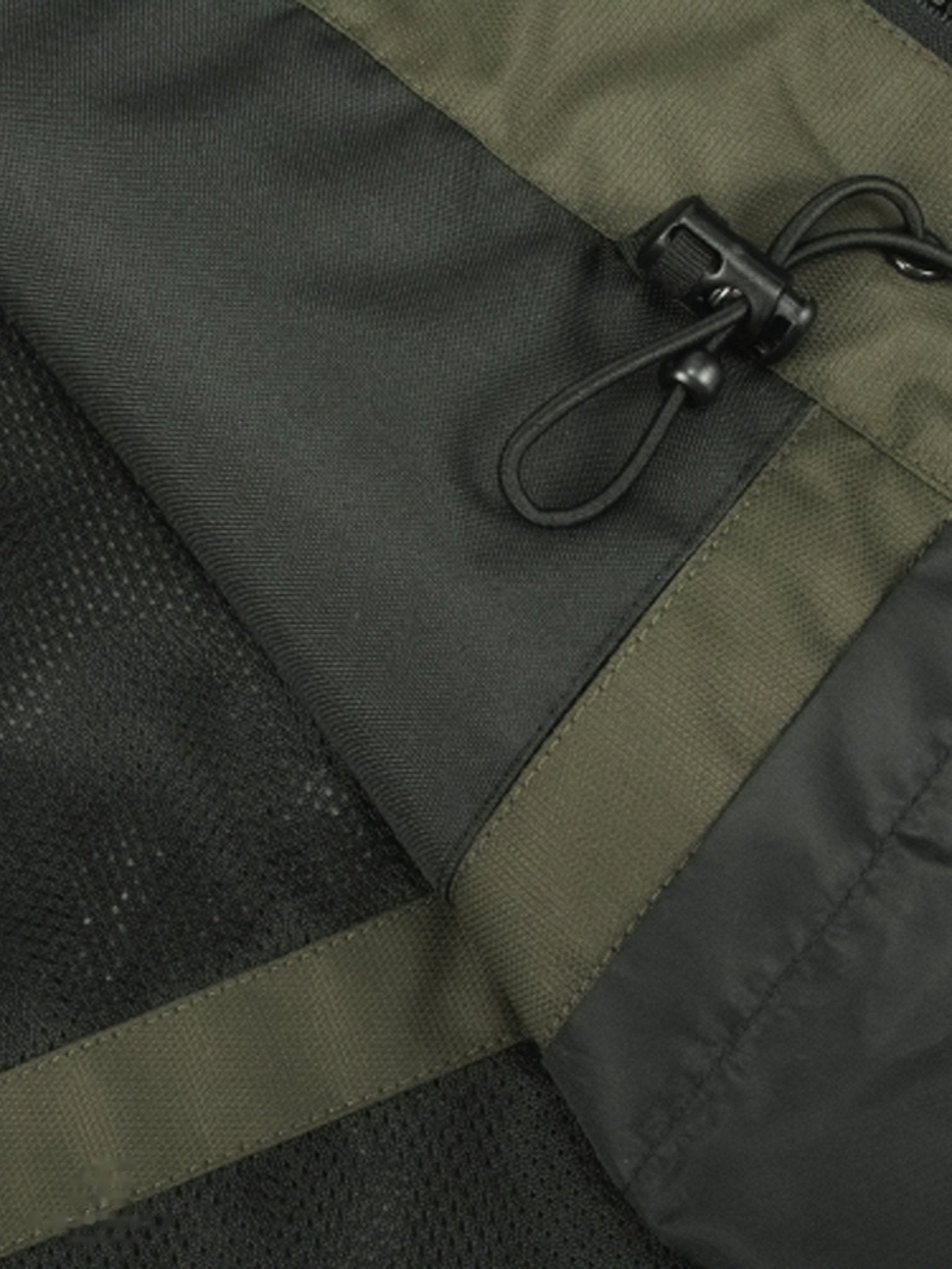 Close-up of a green and black jacket with a zipper pull.