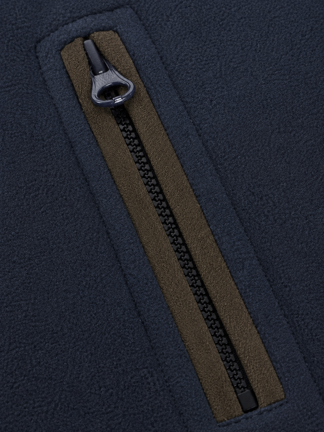 Close-up of a brown zipper on a dark blue fabric background