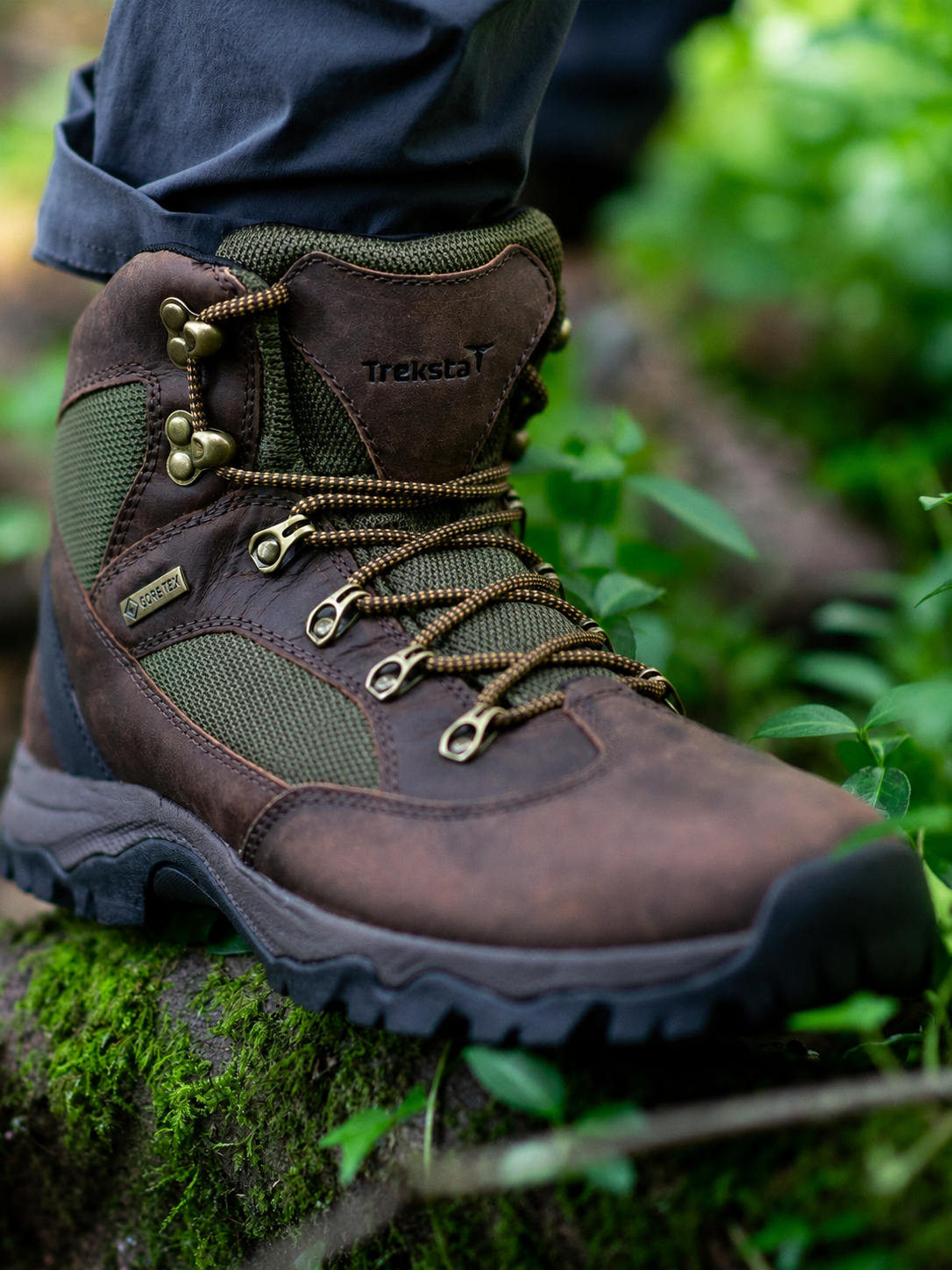 Brown hiking boot with green accents on a natural background