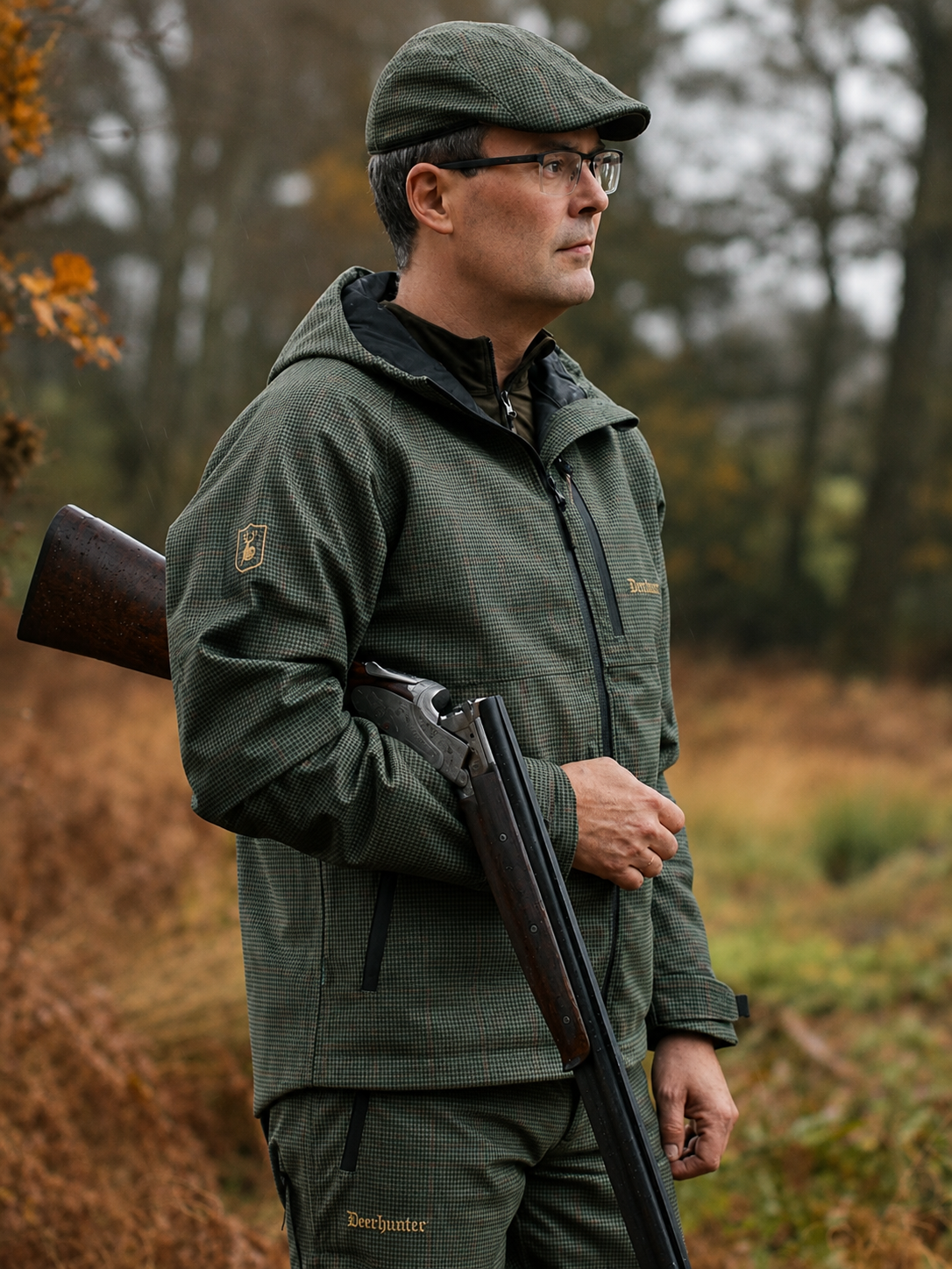 Man in green hunting attire holding a rifle in a forest setting